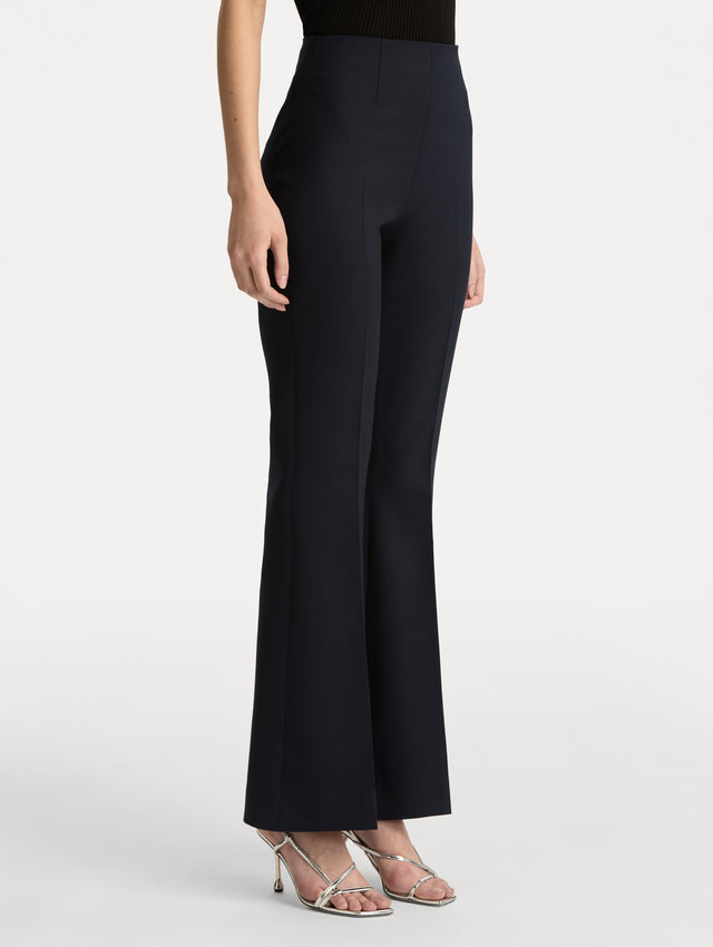 Navy Wool Flared Pants featuring a high waist, front crease detailing, and slightly flared hem. Side View.
