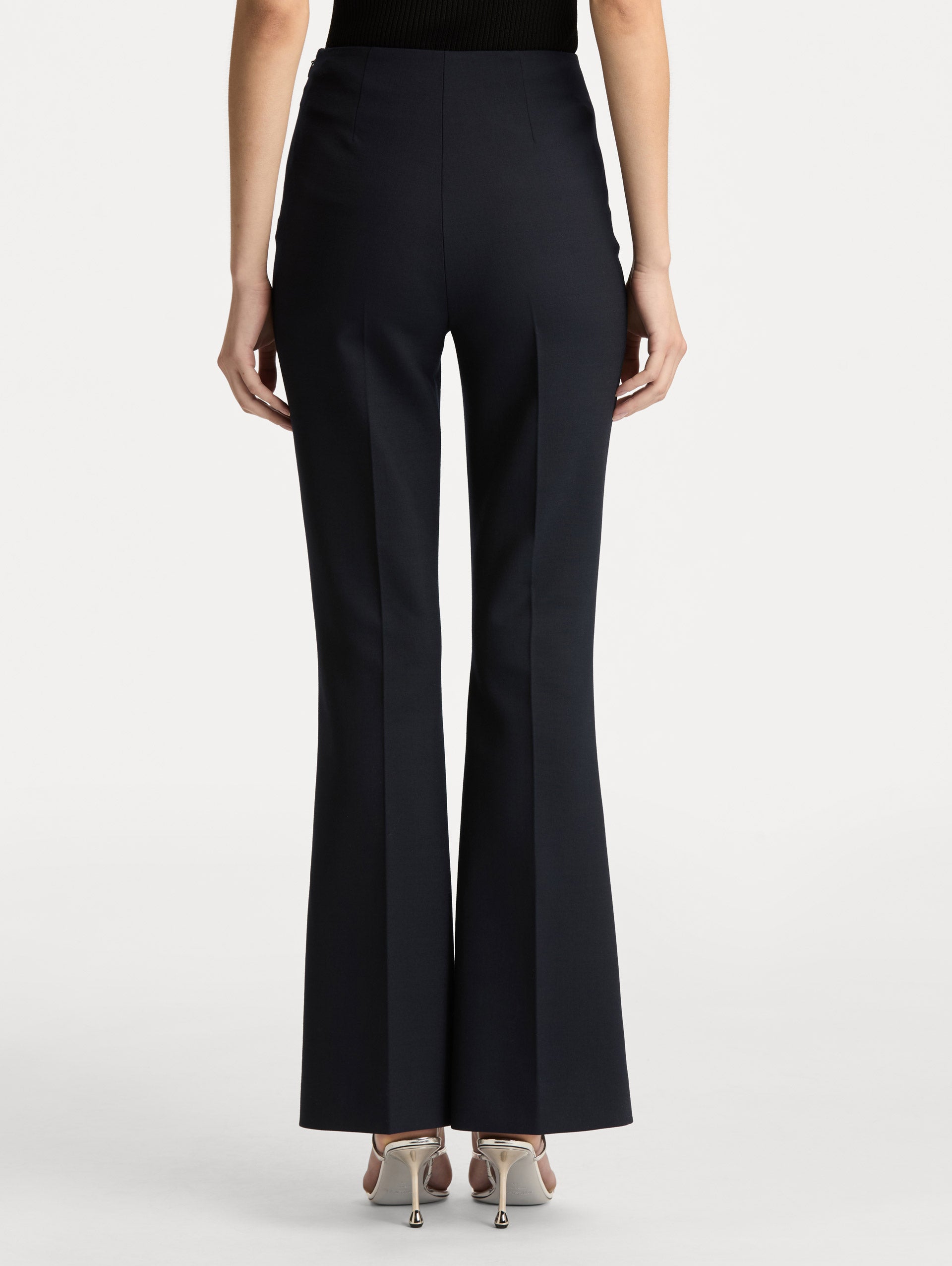 Navy Wool Flared Pants featuring a high waist, front crease detailing, and slightly flared hem. Back View.