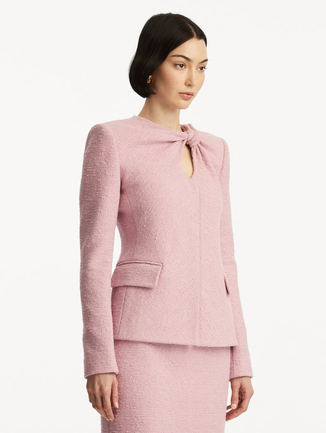 Light pink tweed jacket with a twist detail in the top corner, paired with a matching skirt. Side View.