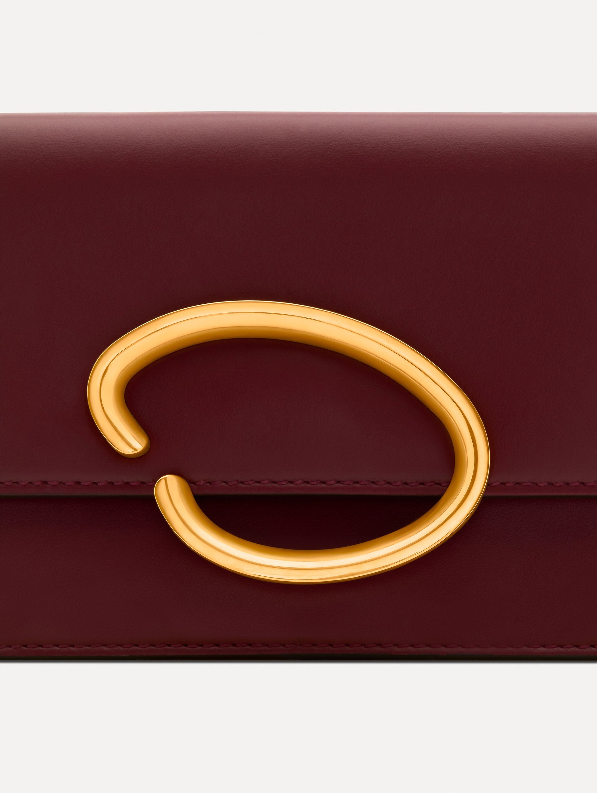 Maroon O Pochette with gold hardware and abstract O Clasp. Zoom View. 