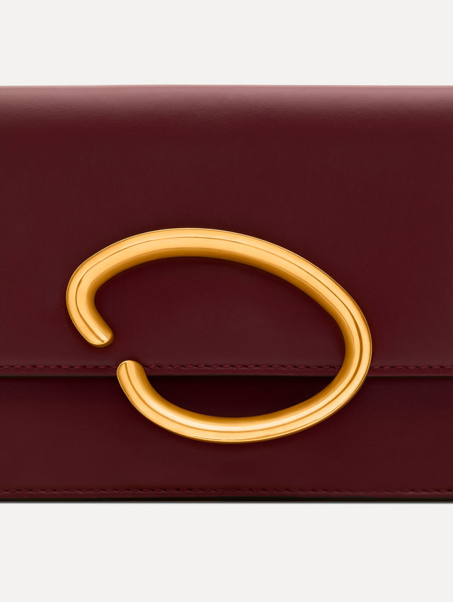 Maroon O Pochette with gold hardware and abstract O Clasp. Zoom View. 