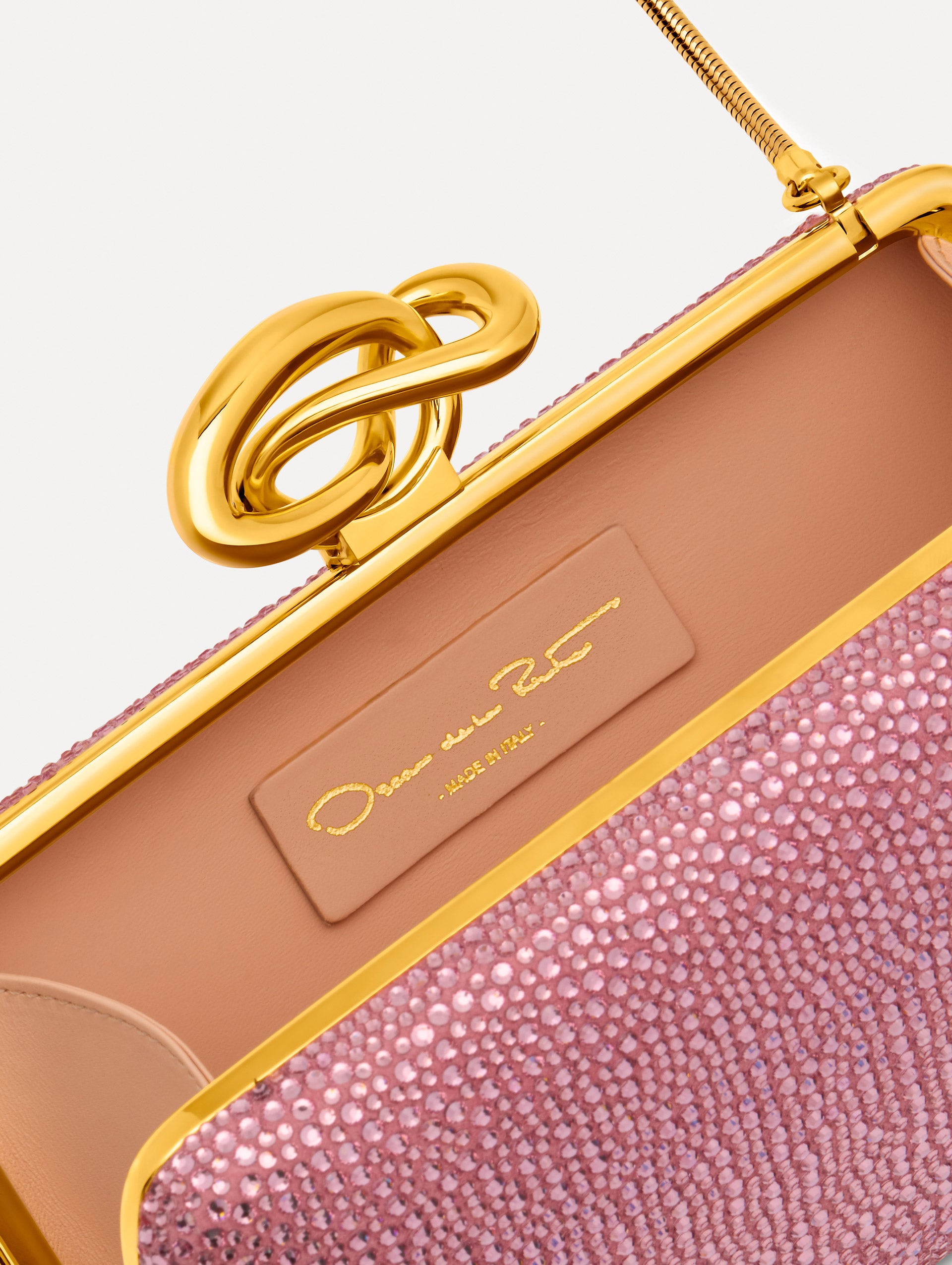Pink Crystal Pavé Knot Minaudière featuring a rectangular silhouette, allover pavé embellishment, and sculptural gold knot clasp. Zoom View.