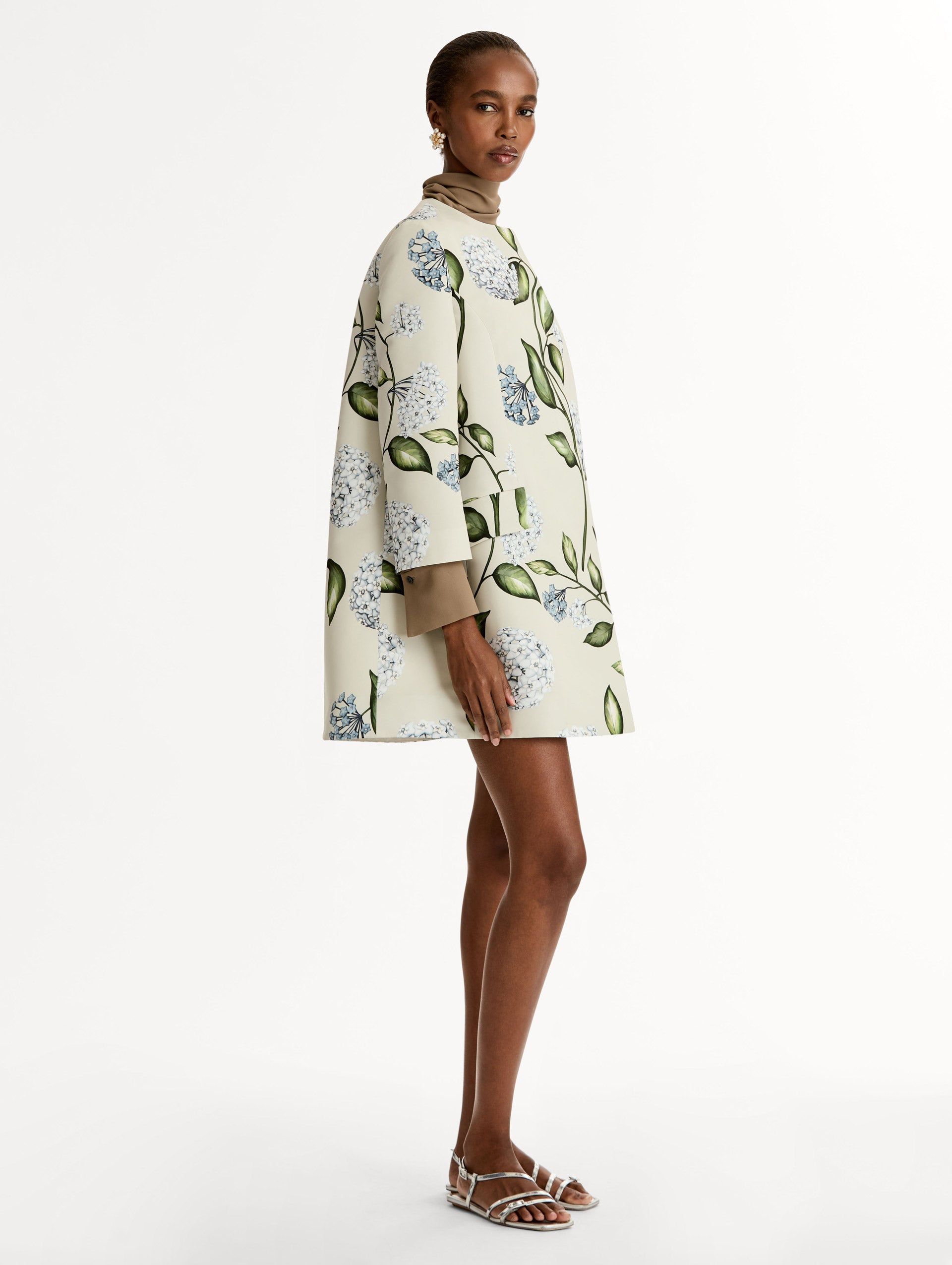 Floral Porcelain Flower Faille Coat in ivory, blue and green. Button closure with long sleeves. Side View. 