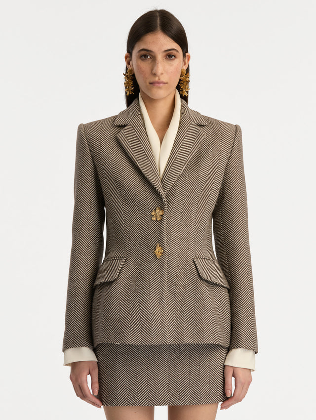 Brown and Ivory Chevron Cashmere-Blend Jacket featuring peak lapels, flap pockets, tailored seams, and gold floral buttons. Front View.
