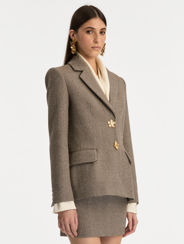 Brown and Ivory Chevron Cashmere-Blend Jacket featuring peak lapels, flap pockets, tailored seams, and gold floral buttons. Side View.
