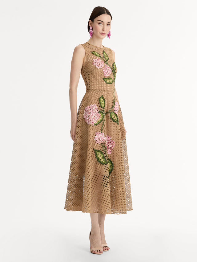 Porcelain flowers stitched with dimensional threadwork into an openwork lattice. Fitted bodice and flared skirt. Side View.