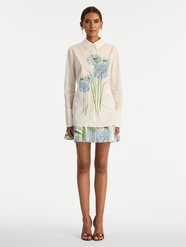 Ivory Allium Cotton Poplin Blouse with long sleeves and blue floral embroidery on the front. Front View.