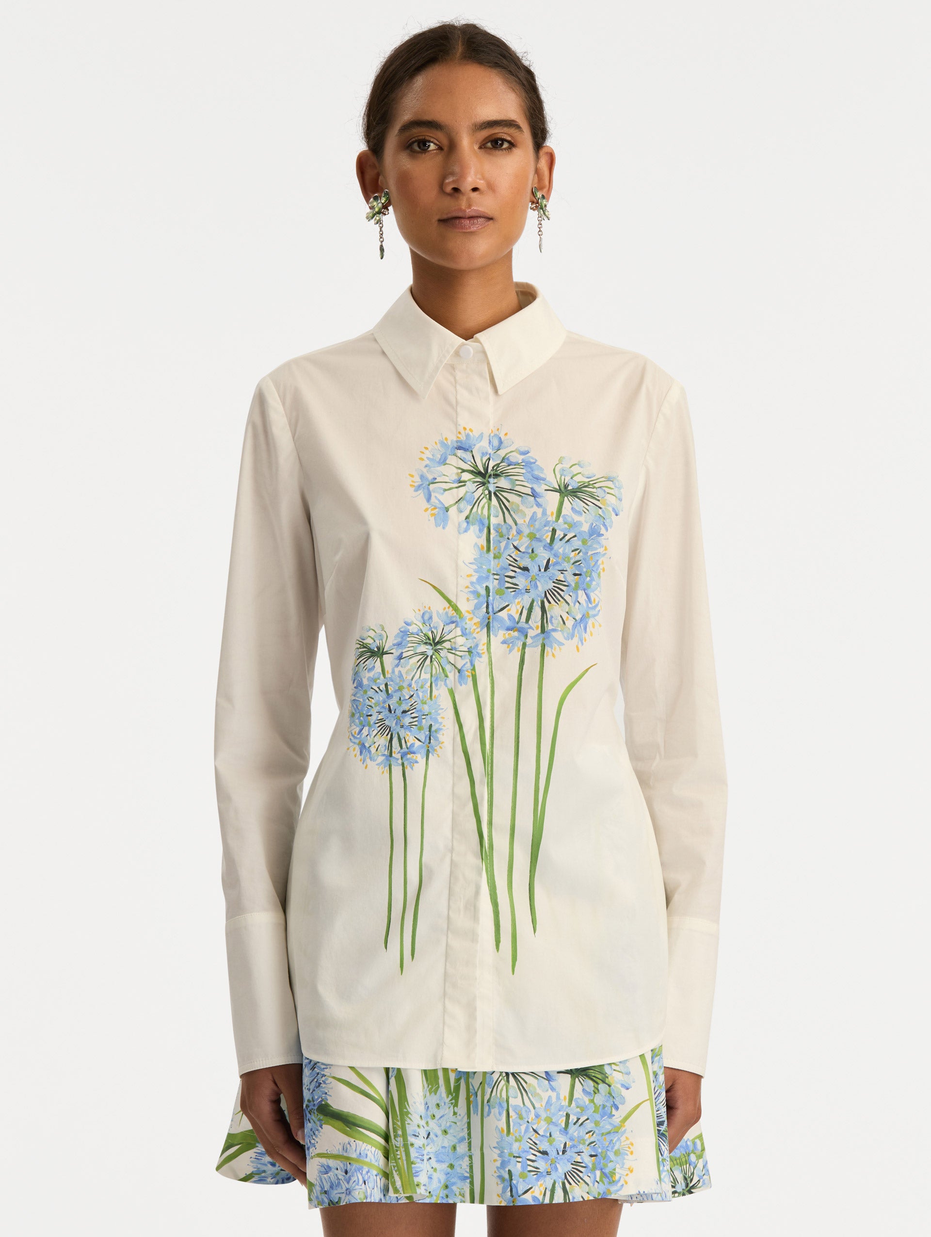 Ivory Allium Cotton Poplin Blouse with long sleeves and blue floral embroidery on the front. Front View.