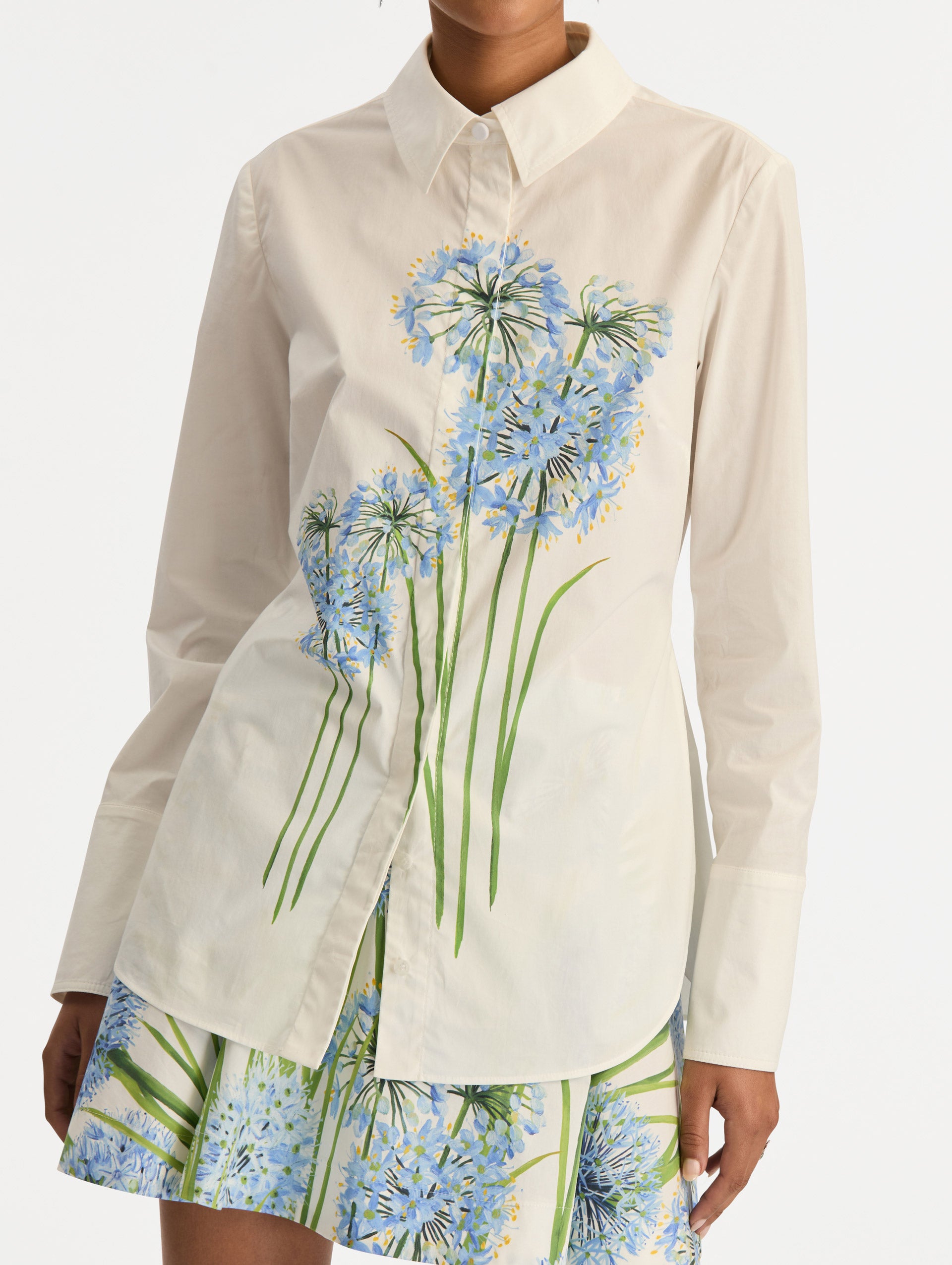 Ivory Allium Cotton Poplin Blouse with long sleeves and blue floral embroidery on the front. Zoom View.