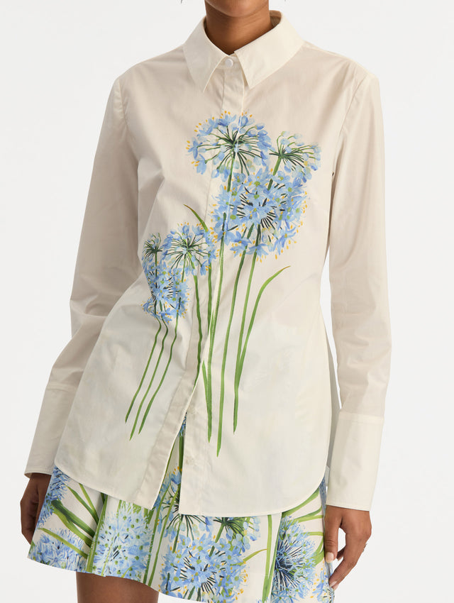 Ivory Allium Cotton Poplin Blouse with long sleeves and blue floral embroidery on the front. Zoom View.