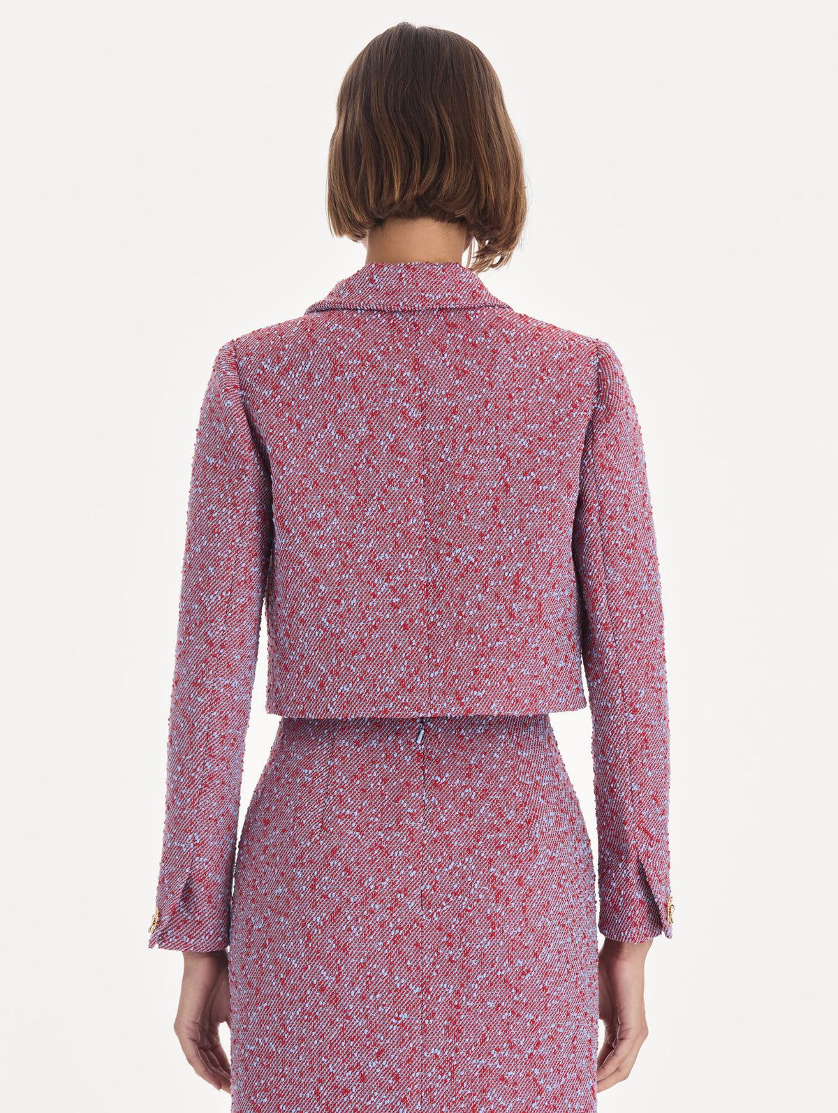 The model is wearing a long sleeve slubby wool tweed gauze jacket. Back view.