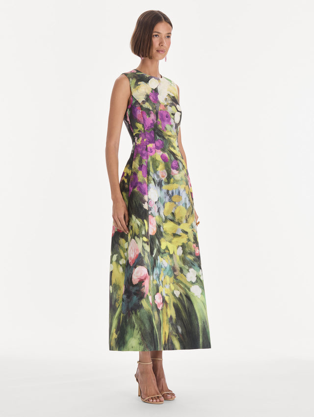 The model is wearing a sleeveless abstract garden faille cocktail dress. Side view.