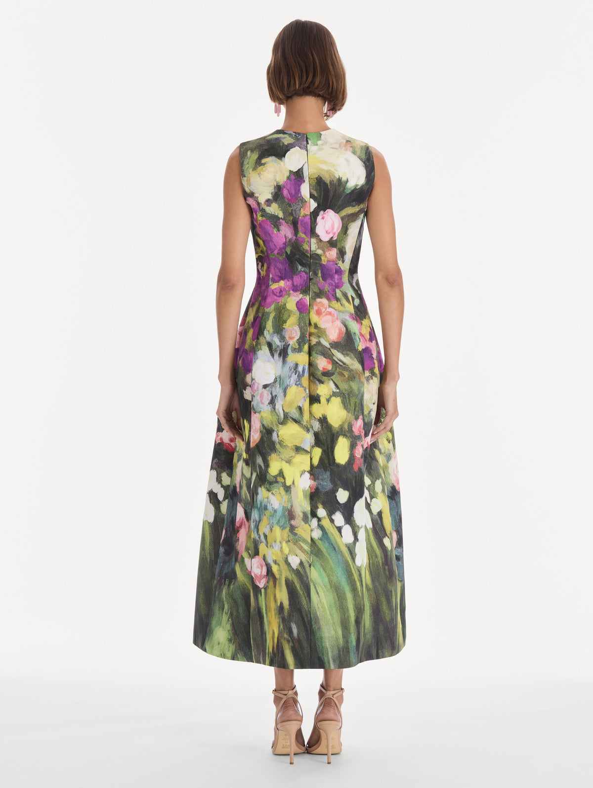 The model is wearing a sleeveless abstract garden faille cocktail dress. Back view.