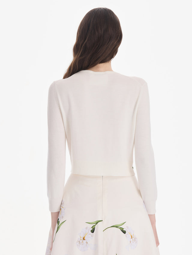 The model is wearing an embroidered cardigan. Back view.
