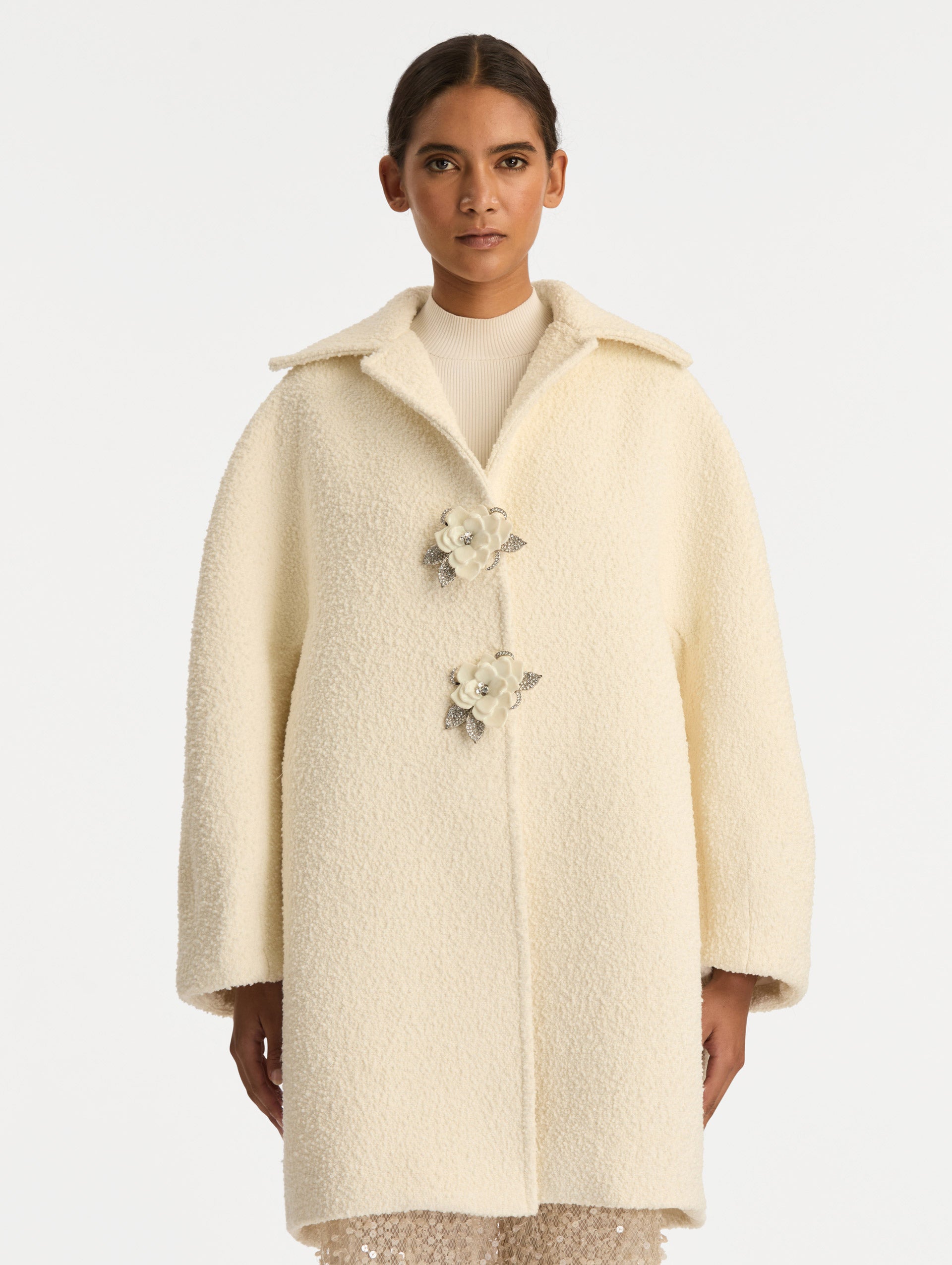 Ivory Floral Button Bouclé Tweed Coat with notched lapels, featuring two floral crystal-embellished clasps at the front. Front View.