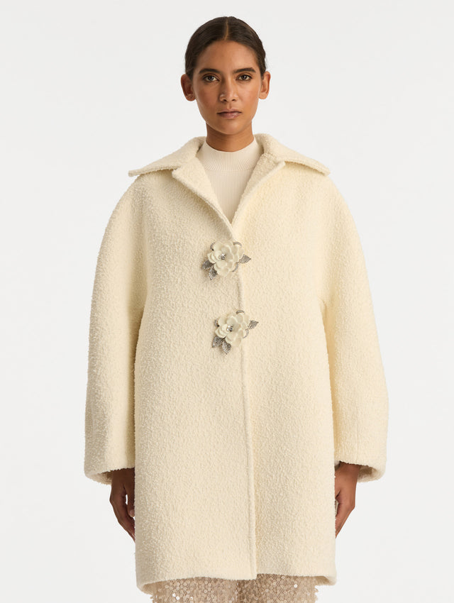 Ivory Floral Button Bouclé Tweed Coat with notched lapels, featuring two floral crystal-embellished clasps at the front. Front View.
