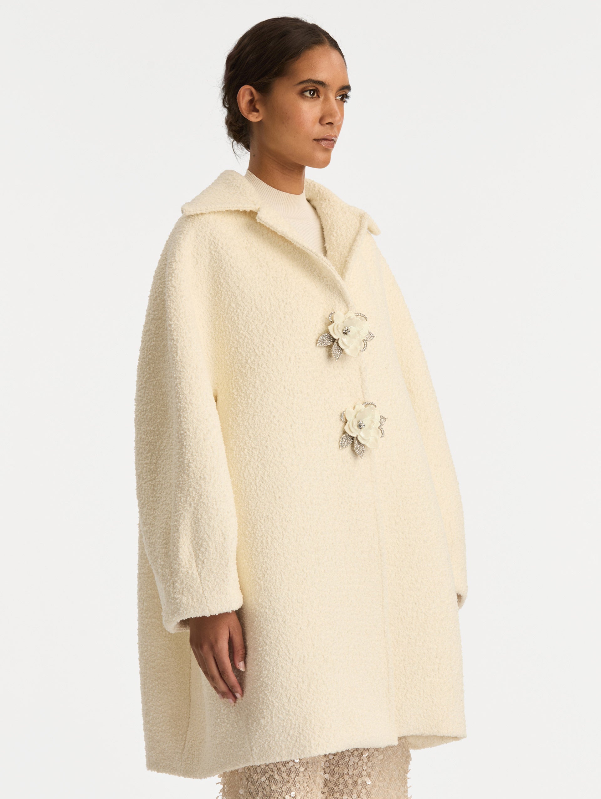 Ivory Floral Button Bouclé Tweed Coat with notched lapels, featuring two floral crystal-embellished clasps at the front. Side View.