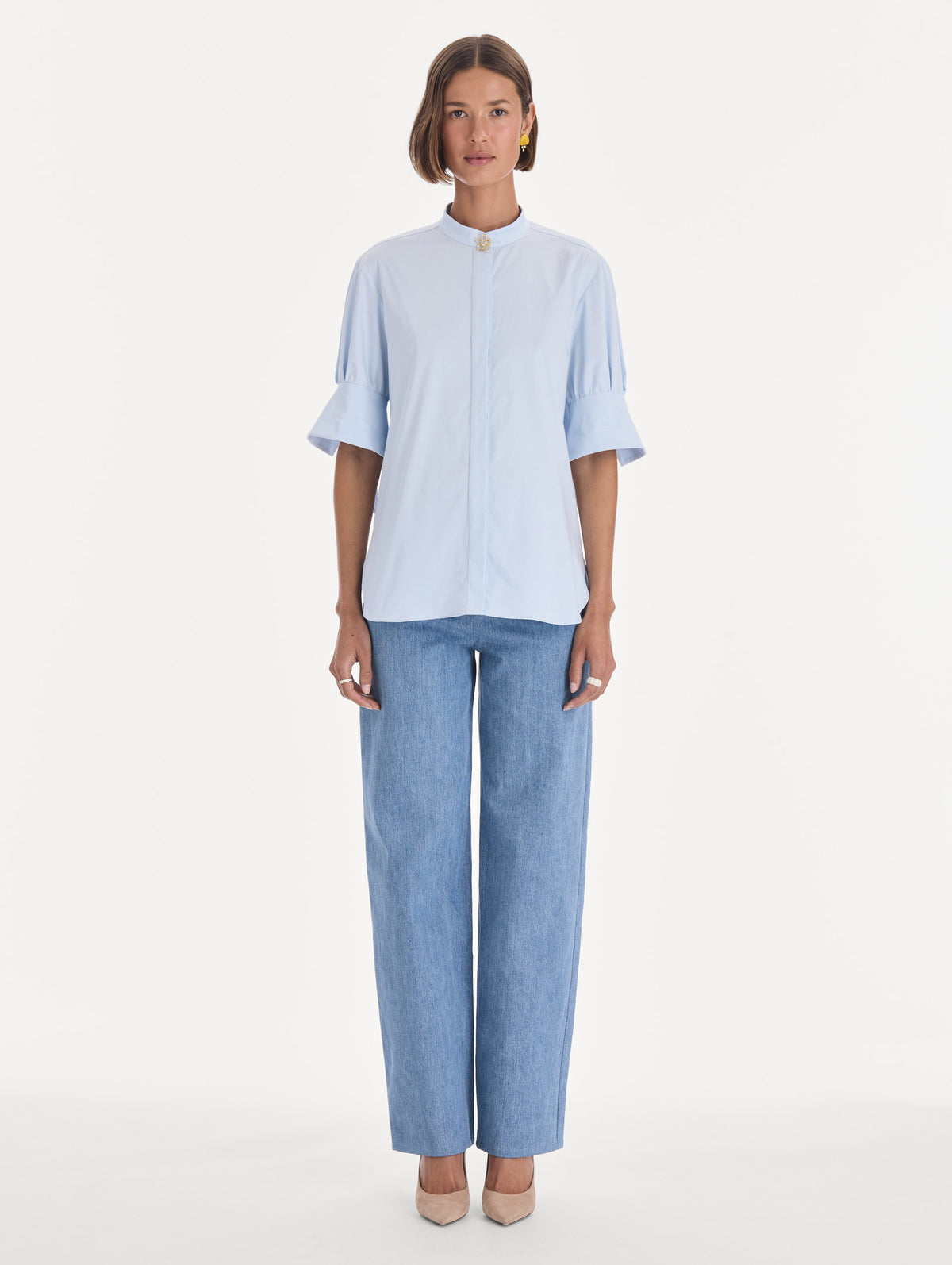 The model is wearing a short sleeve cotton poplin sateen blouse. Front view.
