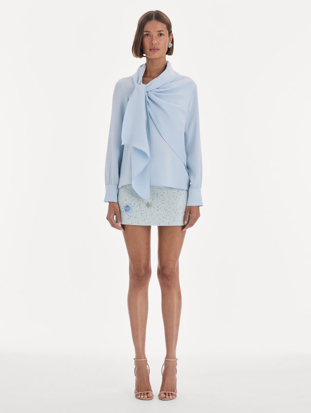 The model is wearing a long sleeve neck tie detail georgette blouse. Front view.