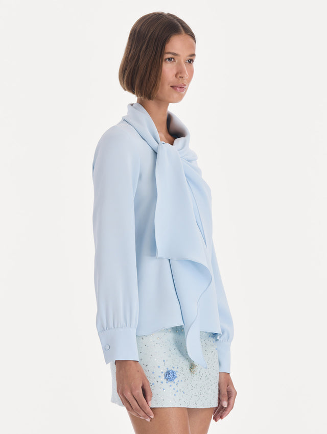 The model is wearing a long sleeve neck tie detail georgette blouse. Side view.