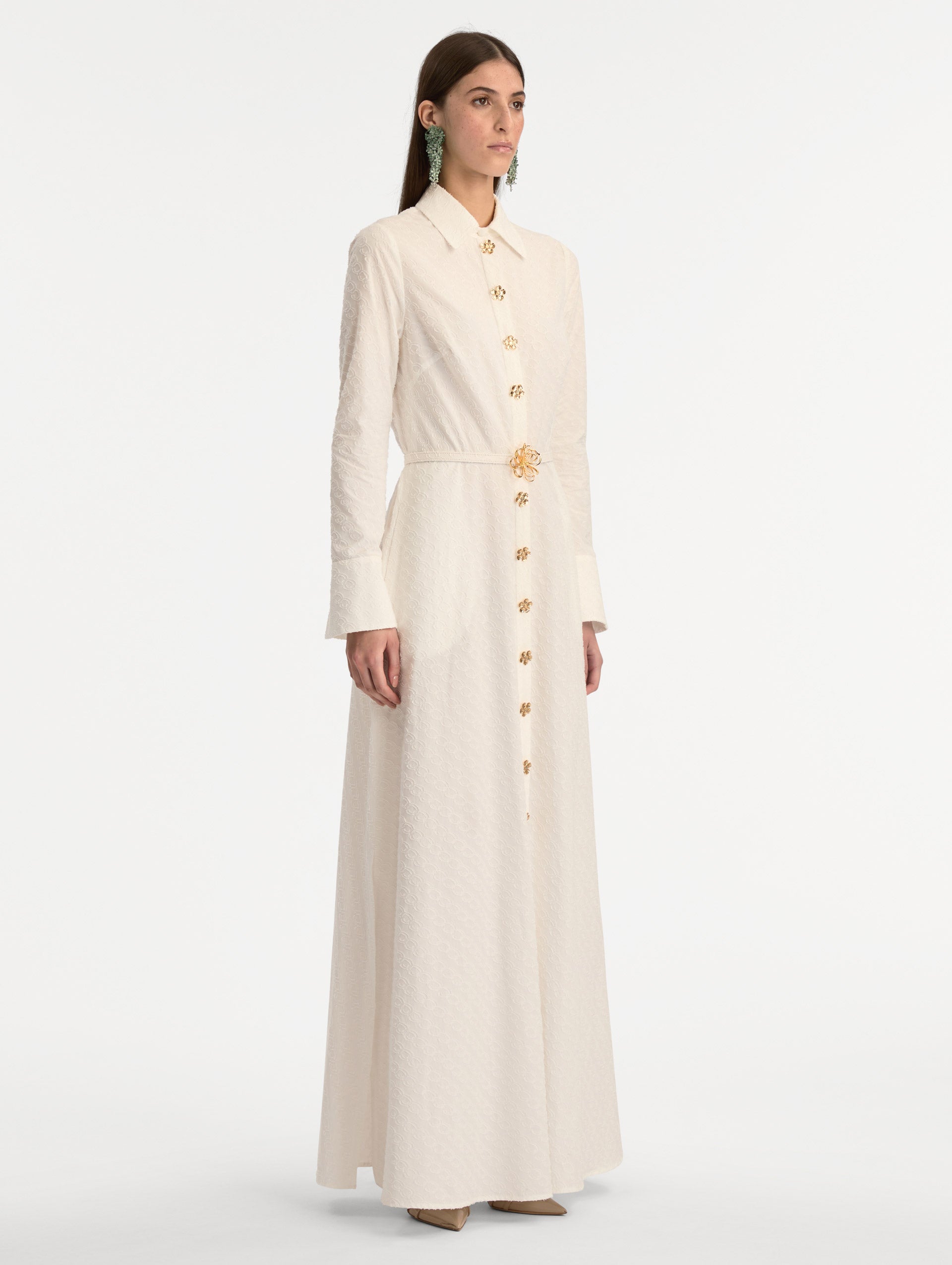 Ivory Oscar Chain-Link Cotton Poplin Caftan featuring a collared neckline, flared sleeves, gold button front, and belted waist with floral buckle. Side View. 