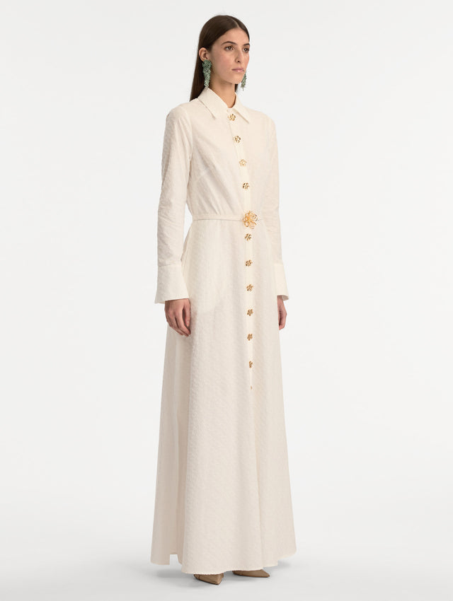 Ivory Oscar Chain-Link Cotton Poplin Caftan featuring a collared neckline, flared sleeves, gold button front, and belted waist with floral buckle. Side View. 