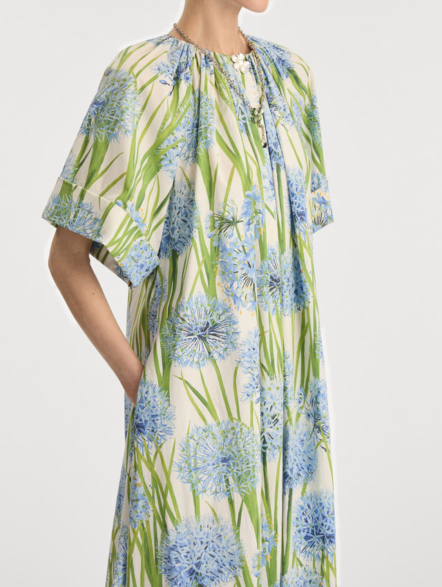Ivory Allium Cotton Poplin Caftan with short sleeves and gathered neckline, featuring an allover blue floral print with green stems. Zoom View.