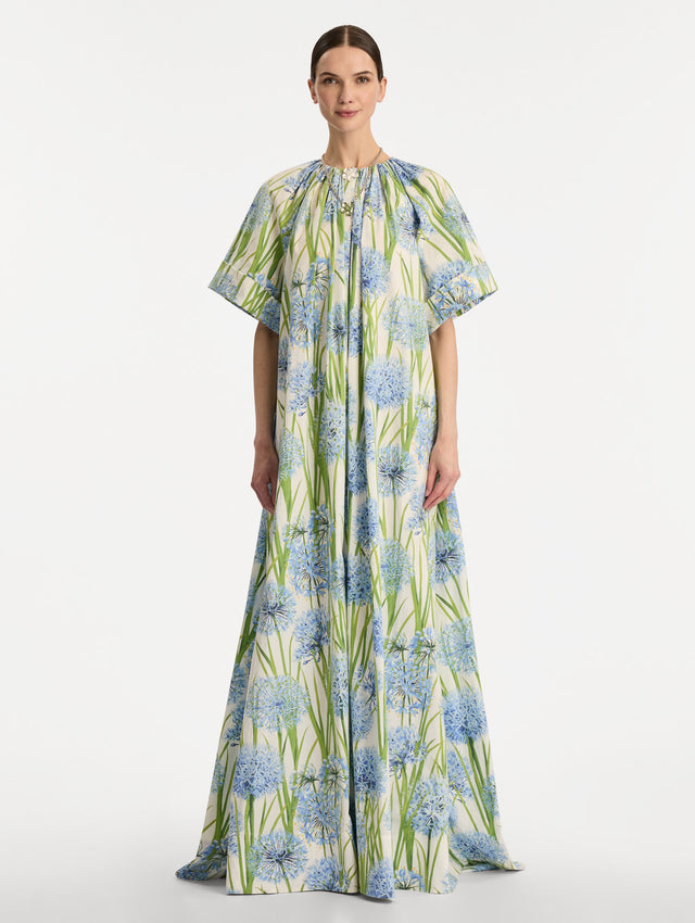 Ivory Allium Cotton Poplin Caftan with short sleeves and gathered neckline, featuring an allover blue floral print with green stems. Front View.