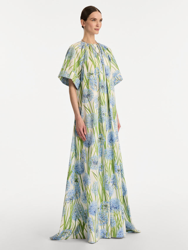 Ivory Allium Cotton Poplin Caftan with short sleeves and gathered neckline, featuring an allover blue floral print with green stems. Side View.