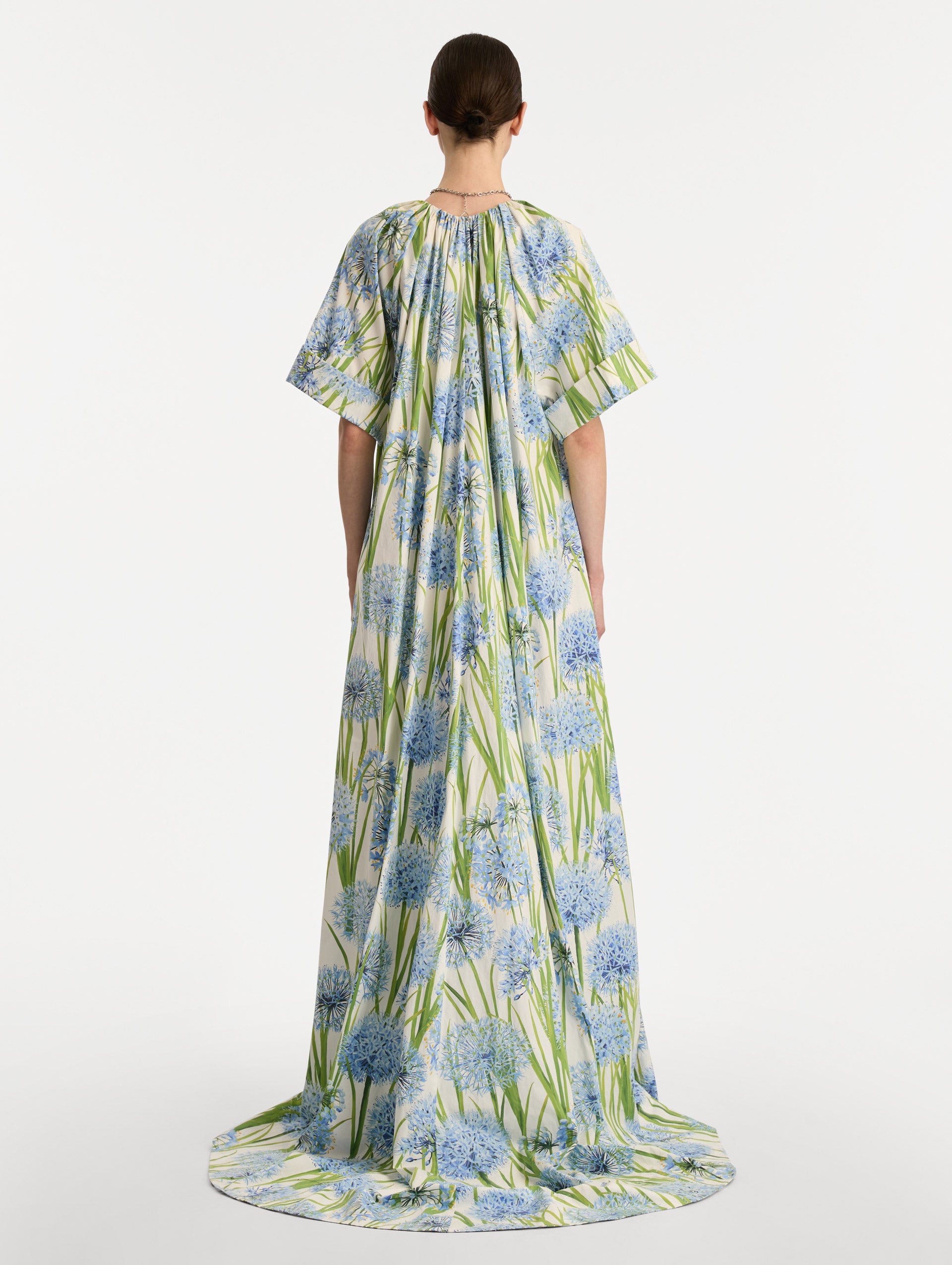 Ivory Allium Cotton Poplin Caftan with short sleeves and gathered neckline, featuring an allover blue floral print with green stems. Back View.