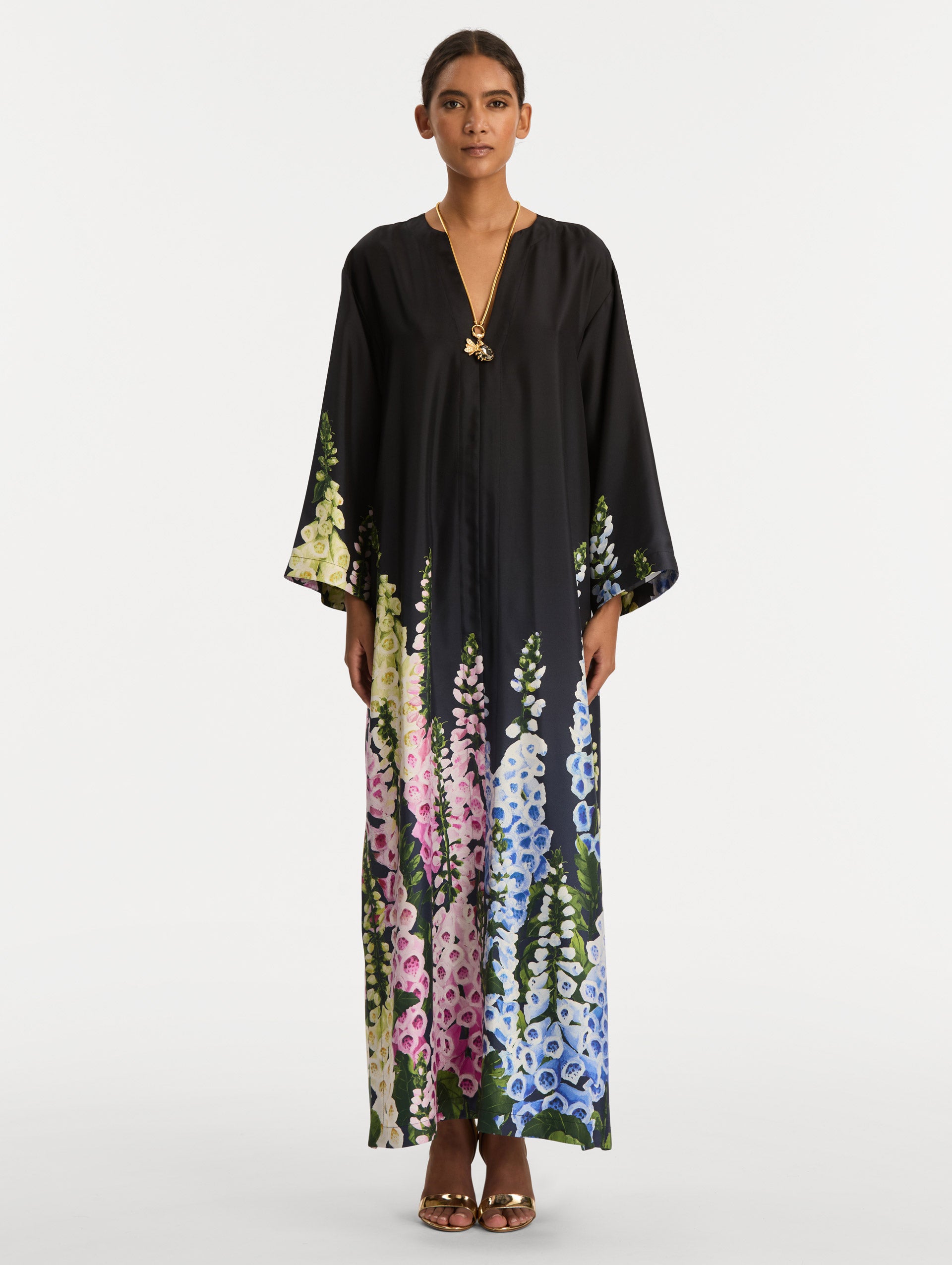 Black Degradé Foxglove Silk Twill Caftan with long sleeves, decorated with multicolor foxglove floral prints along the hem and sleeve edges. Front View.