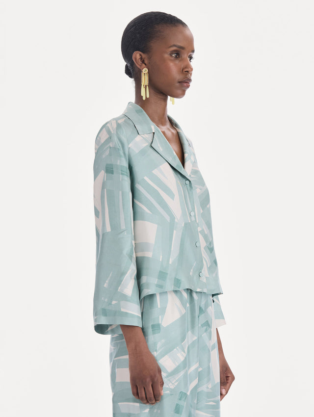 The model is wearing a long sleeve stripey plaid silk twill blouse. Side view.