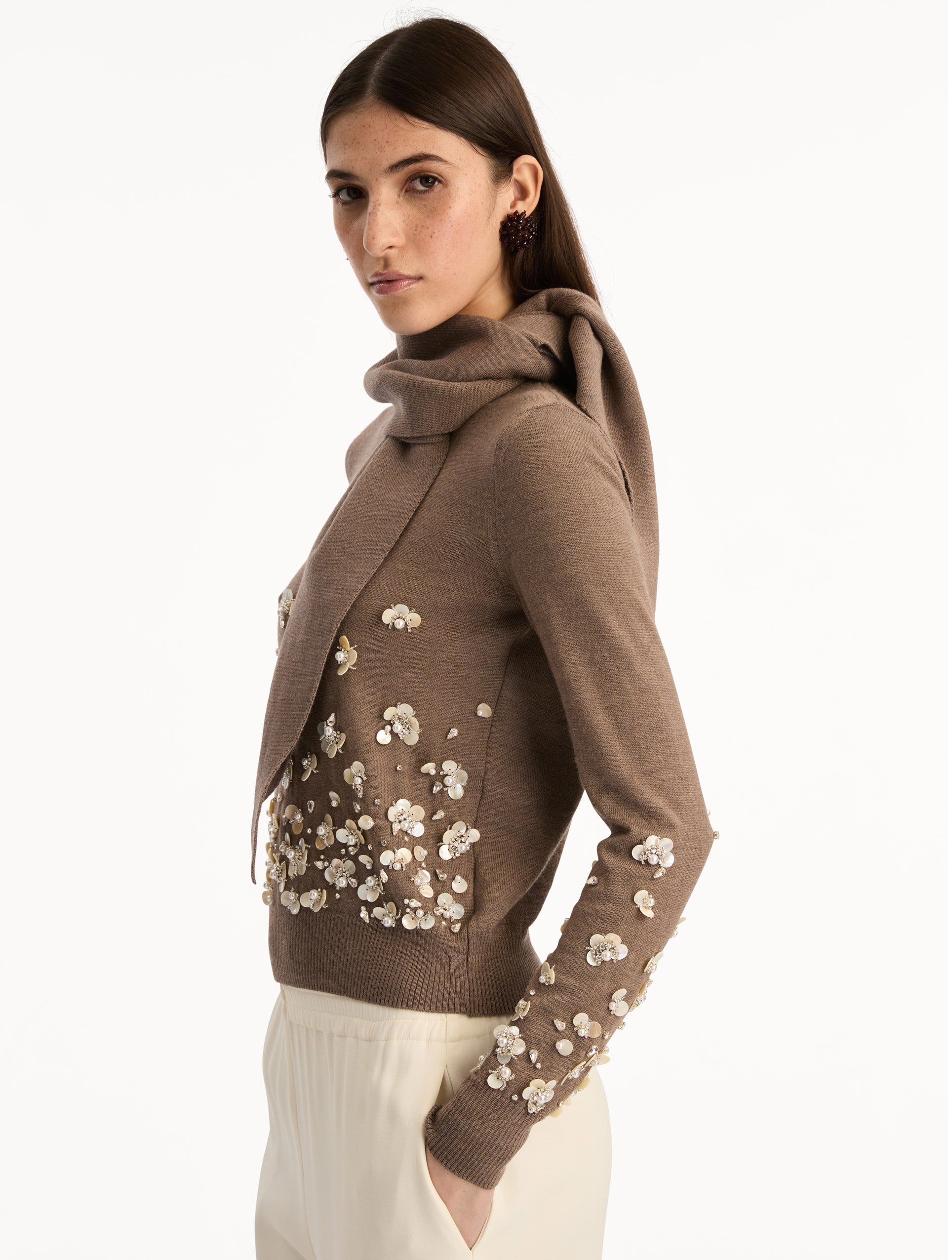 Brown Mother of Pearl Embroidered Pullover with Scarf featuring an attached draped scarf neckline and sequin floral embroidery along the hem and sleeves. Side View.