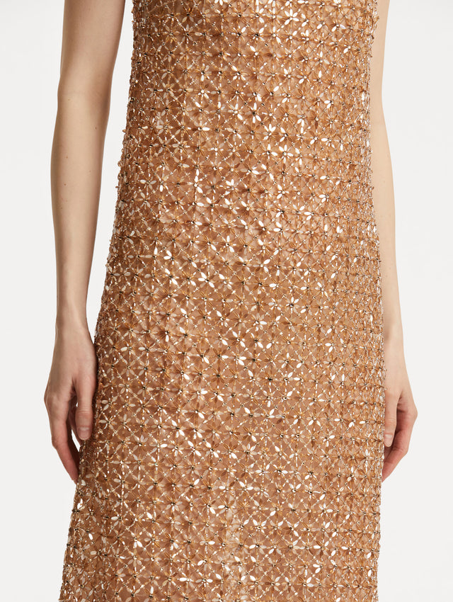 Zoomed in image of amber-hued glass floral embroidery in a grid pattern. 