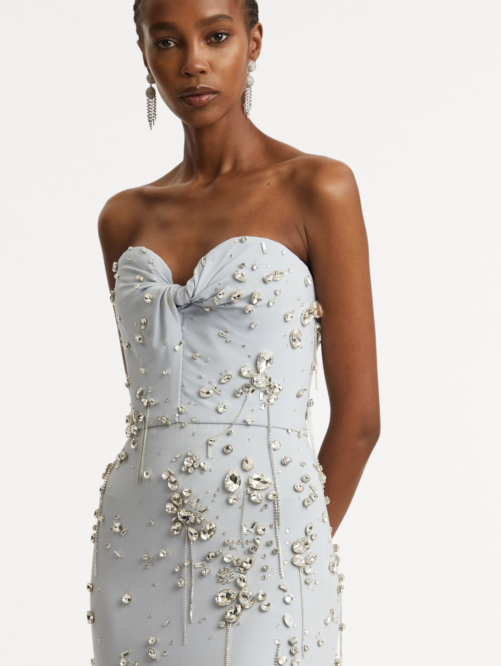 Zoomed in image of twist-detail on the sweetheart neckline with multi-dimensional stones scattered across the dress. 