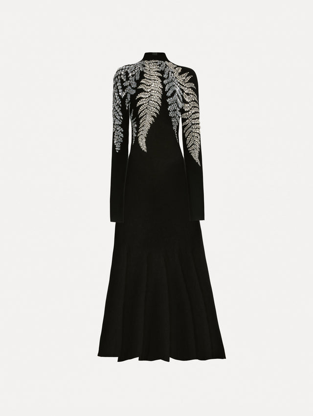 Black long sleeve dress with a mock neckline and flared skirt. Features metallic fern embroidery along neck and shoulders. 