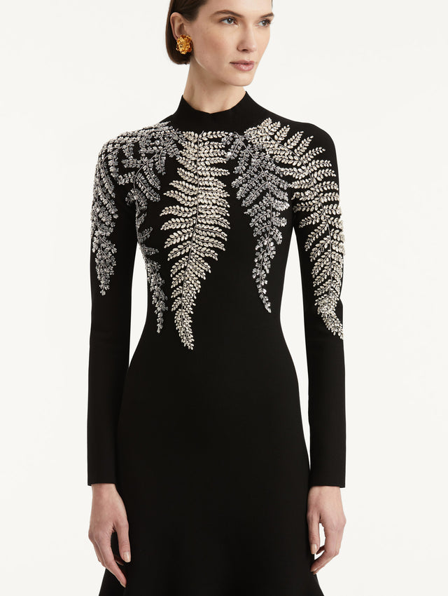 Zoomed in image of metallic fern embroidery along the mock neck and shoulders. 