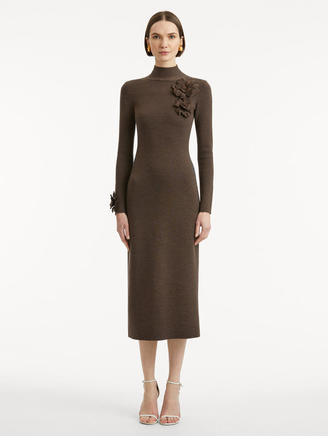 Full body front view of model wearing a long sleeve dark brown dress with a pencil silhouette and mock neckline. Tonal peony appliqués, with beaded detailing, frame the neckline and sleeves.