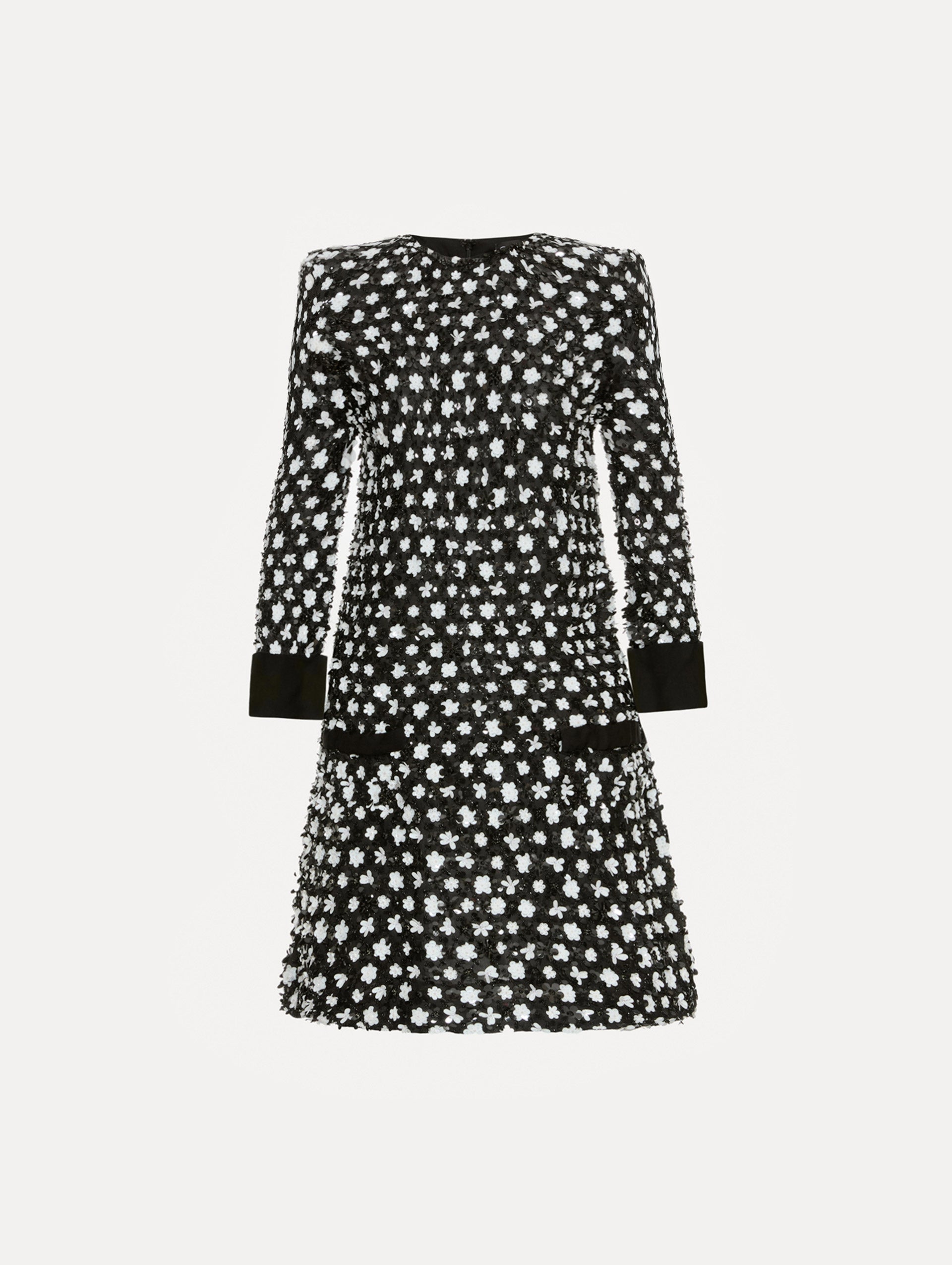 Dress with black and ivory floral sequin embroidery across the dress with three-quarter length sleeves. Features black cuffs and black non functional buttons.  