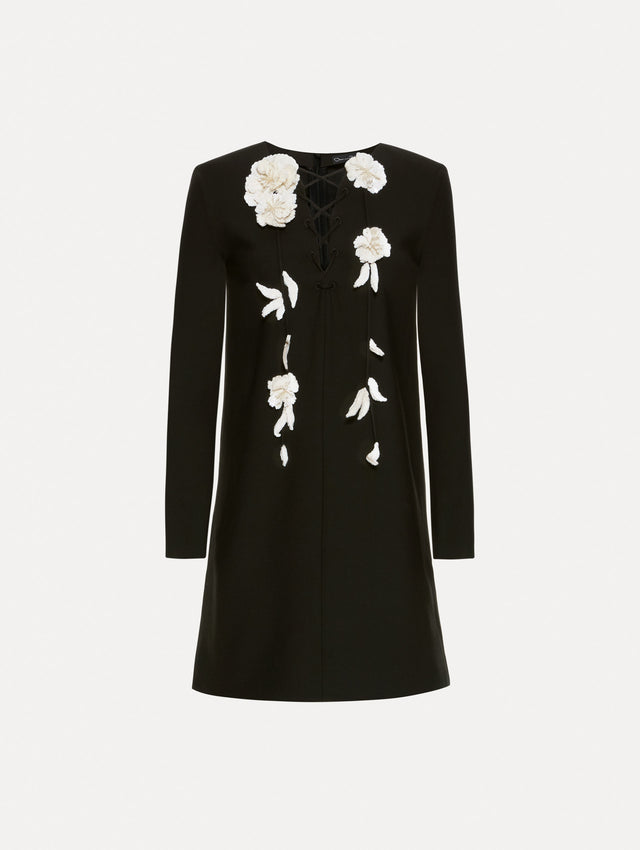 Wool minidress in black with long sleeves, lace-up neckline and white embroidered sequin floral appliqués.