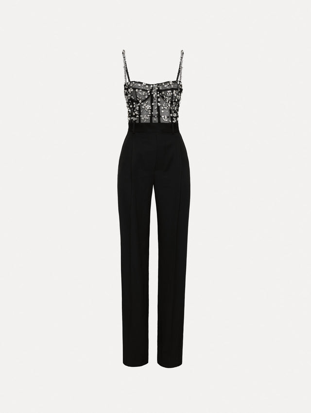 Black jumpsuit with multi-dimensional stones scattered across a tulle bodice and crystal shoulder straps. Features black straight leg pants with side pockets and belt loops. 