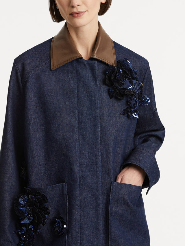 Zoomed in image of front patch pockets, featuring navy peony embroidery and a contrasting brown leather spread collar. 