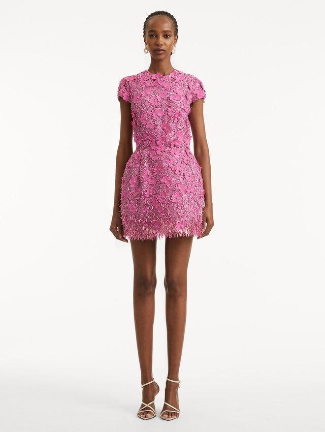 Full body front view of model wearing a pink cocktail mini with floral sequin embroidery and jewel neckline. With short sleeves and a cupcake silhouette.