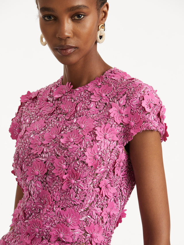 Zoomed in image of pink floral sequin embroidery and jewel neckline, with short sleeves.