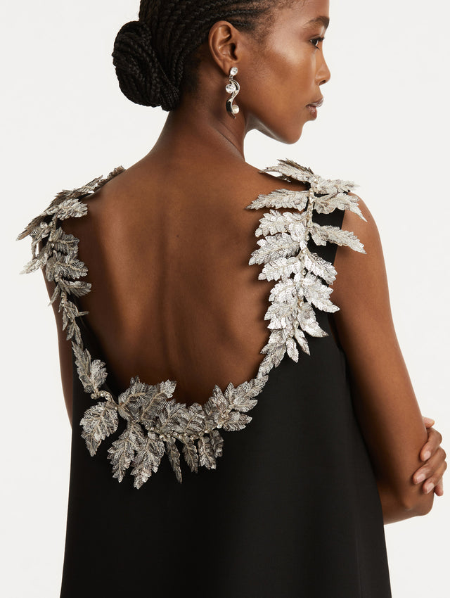 Zoomed in image of silver sequin fern embroidery following the scoop back. 