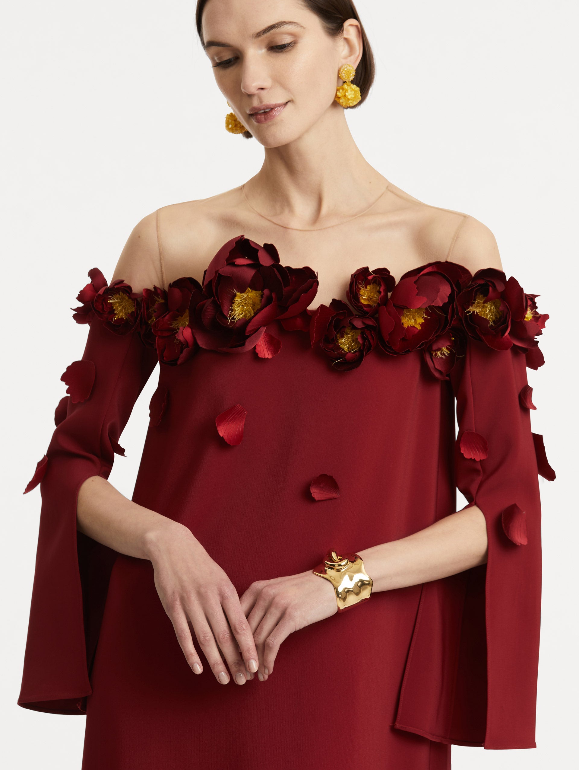 Zoomed in view of peony appliqués on red caftan. 