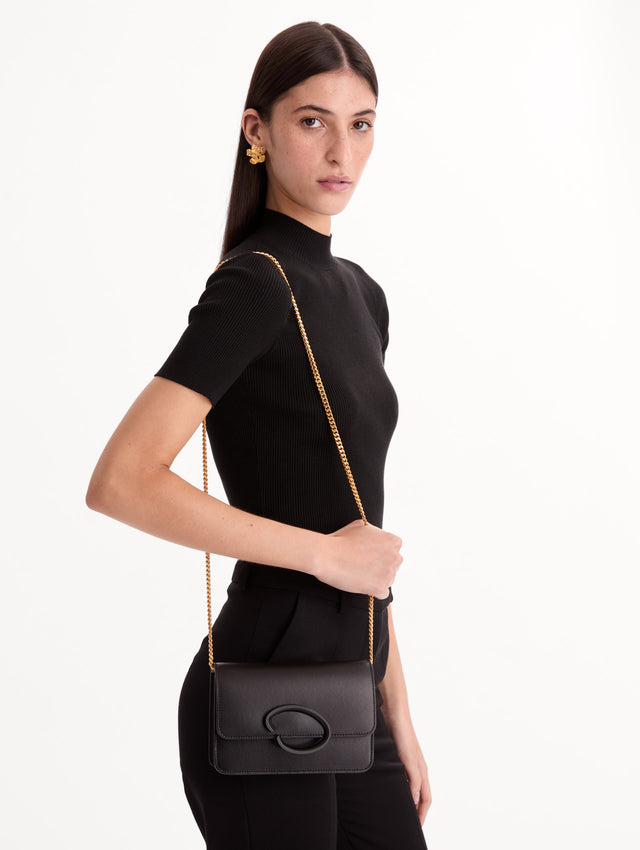 Black O Pochette with gold hardware and abstract O motif clasp. Front View.