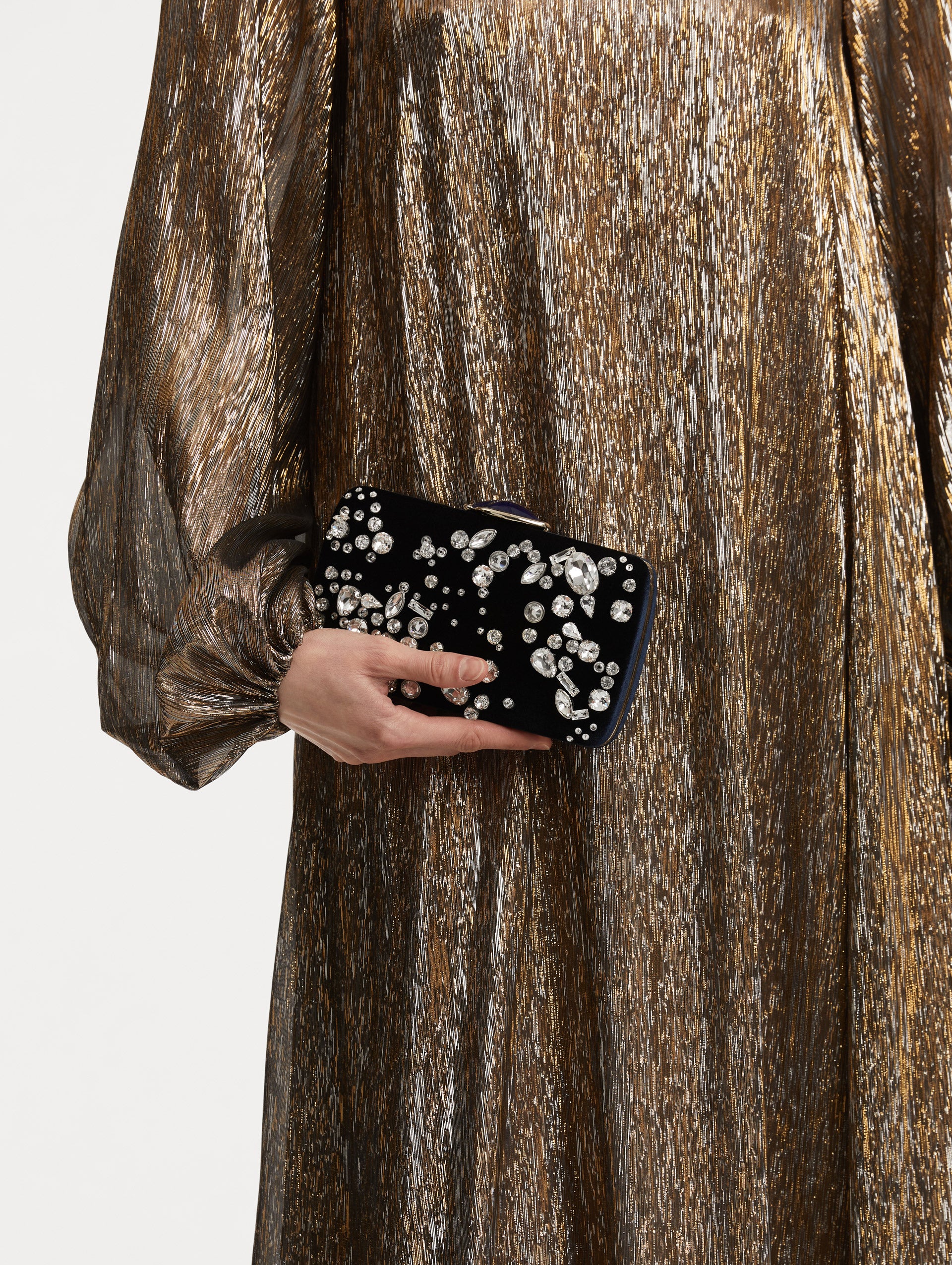 Model holding clutch with multi-dimensional crystal embroidery and faceted stones scattered across canvas. The clutch features the Oscar ‘O’ emblem at the clasp. 