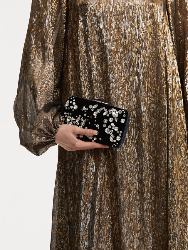 Model holding clutch with multi-dimensional crystal embroidery and faceted stones scattered across canvas. The clutch features the Oscar ‘O’ emblem at the clasp. 