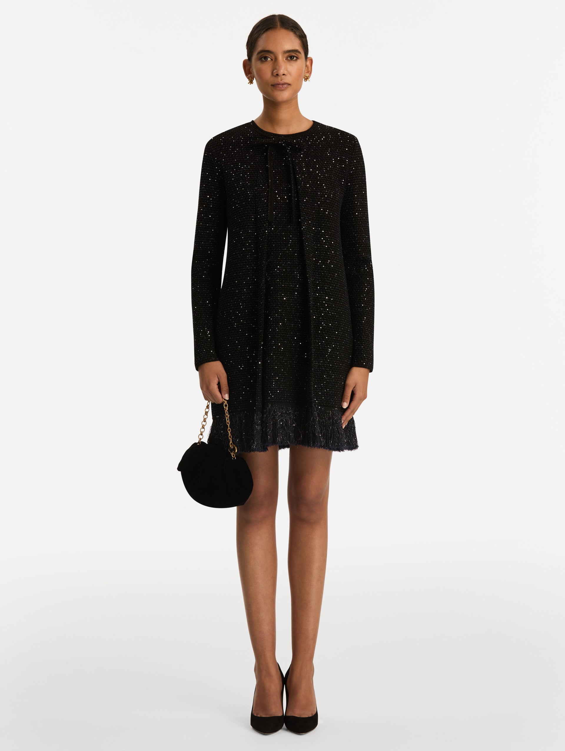 The Velvet Clutch in black features fabric folding, where the velvet is gathered and secured with a voluminous bow. 